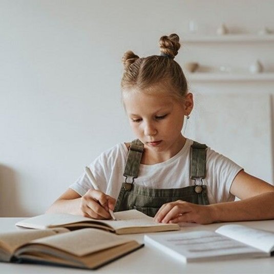 Meisje aan tafel aan het schrijven